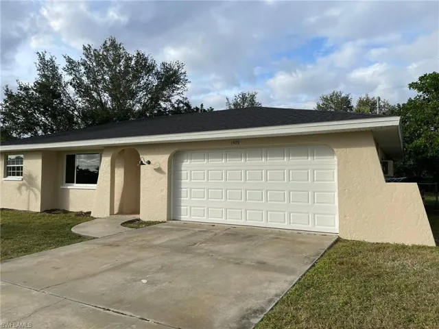 Ranch-style house with concrete driveway, a front yard, roof with shingles, stucco siding, and an attached garage