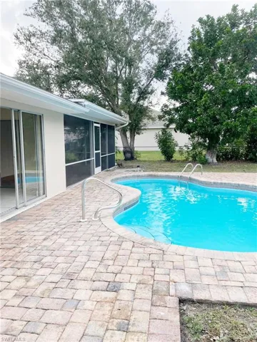 Outdoor pool featuring a patio and a sunroom