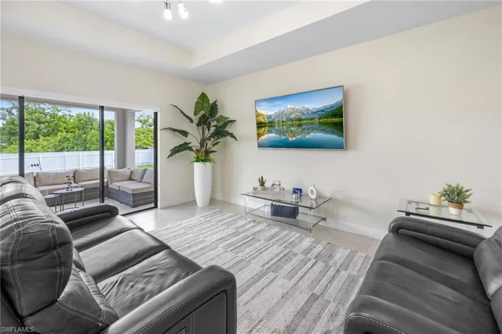 Living room with a raised ceiling and light tile patterned flooring