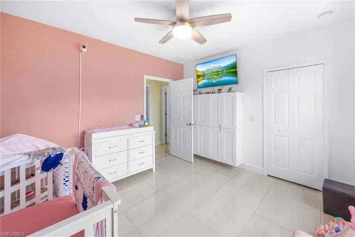 Bedroom with light tile patterned flooring, a ceiling fan, and a closet