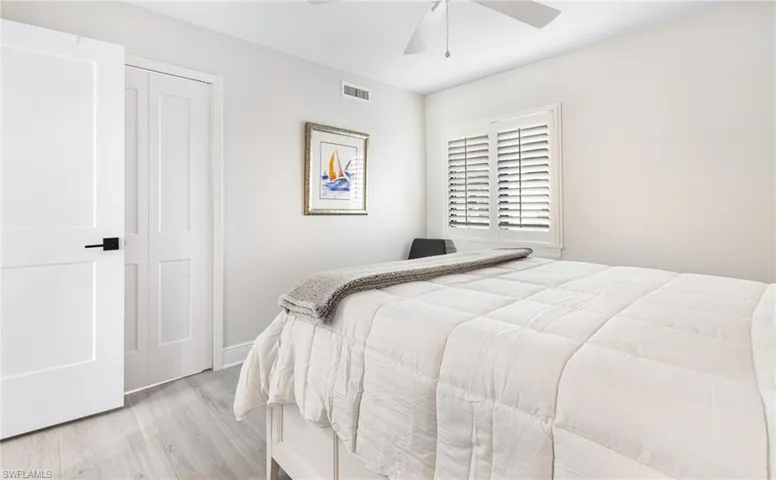 Bedroom with light hardwood / wood-style flooring, a closet, and ceiling fan