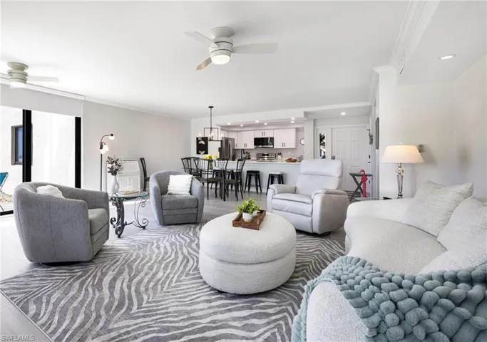 Living room with ornamental molding and ceiling fan