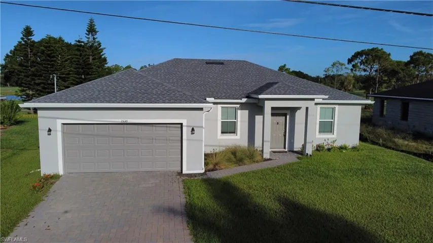 Contemporary single-story residence featuring a gray exterior, dark gray shingle roof, and an attached two-car garage with a matching gray door