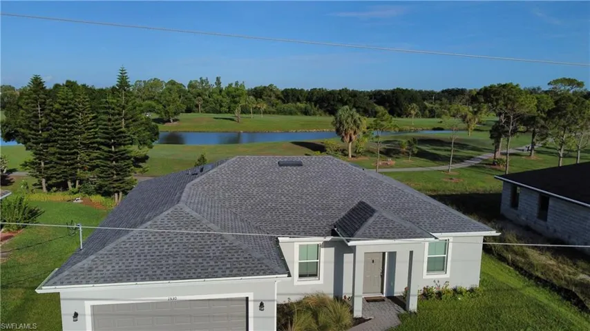 Contemporary single-story home featuring a grey shingle roof and light grey exterior siding