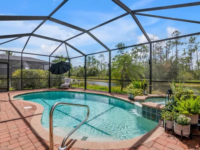 View of pool with a lanai, a patio, and a water view