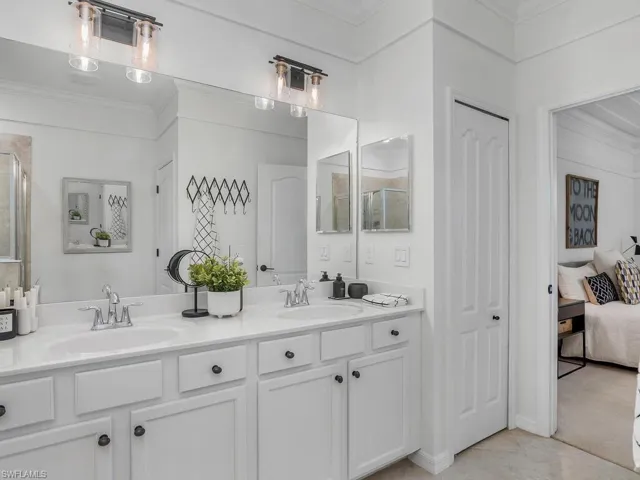 Bathroom featuring walk in shower, crown molding, and vanity