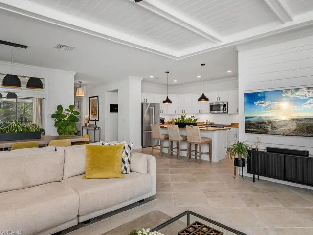 Tiled living room featuring crown molding and beamed ceiling