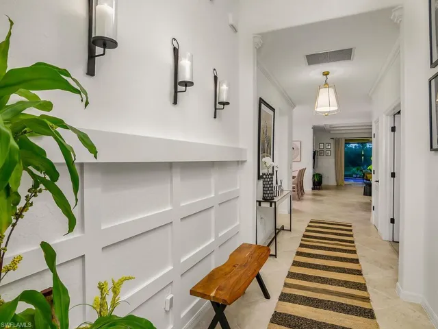 Hall featuring crown molding and light tile patterned flooring