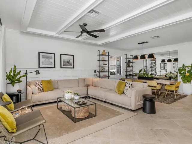 Tiled living room featuring beamed ceiling and ceiling fan
