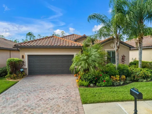 Mediterranean / spanish-style home with a garage and a front lawn