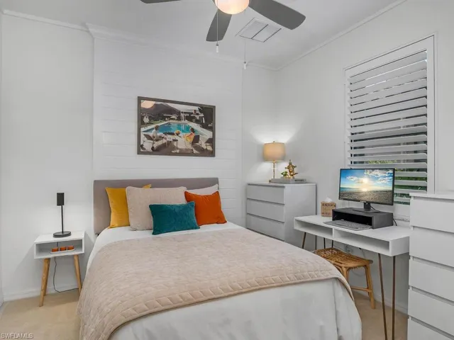 Carpeted bedroom with crown molding and ceiling fan
