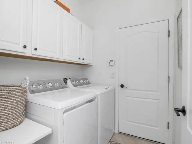 Laundry area featuring washing machine and clothes dryer and cabinets