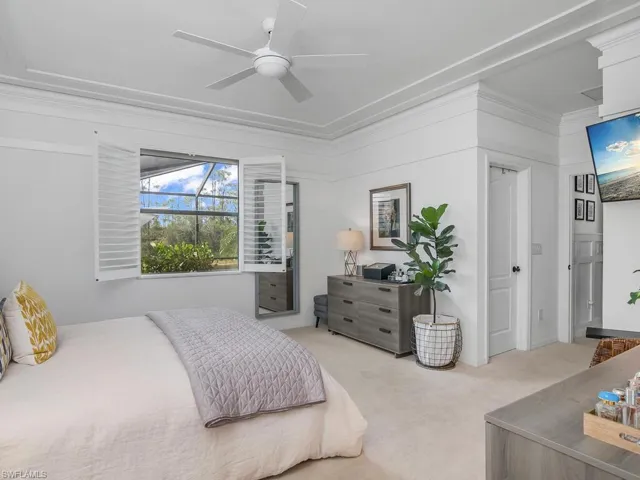 Carpeted bedroom with ceiling fan and ornamental molding
