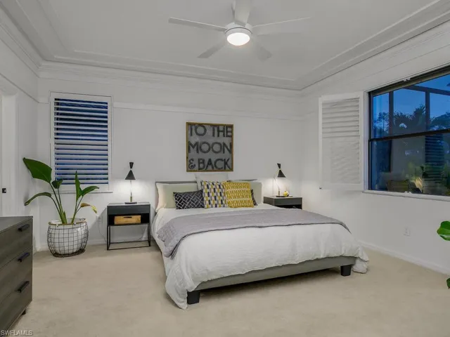 Bedroom with ceiling fan, carpet, and crown molding