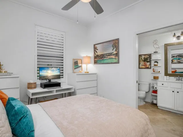 Bedroom featuring crown molding, ceiling fan, sink, and light tile patterned flooring