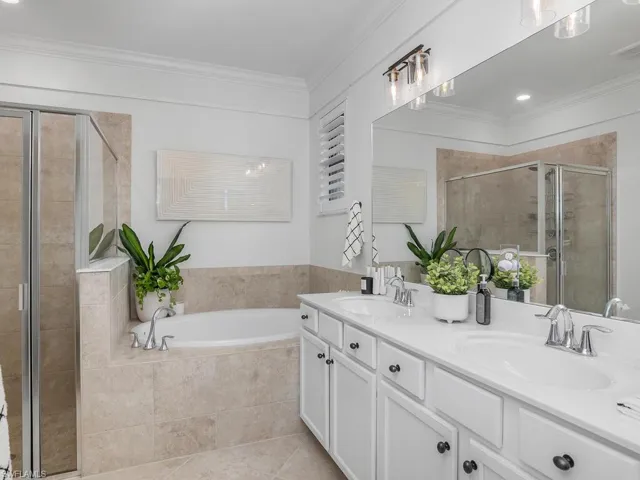 Bathroom with ornamental molding, vanity, plus walk in shower, and tile patterned flooring