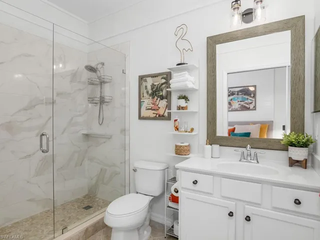 Bathroom featuring vanity, toilet, and an enclosed shower