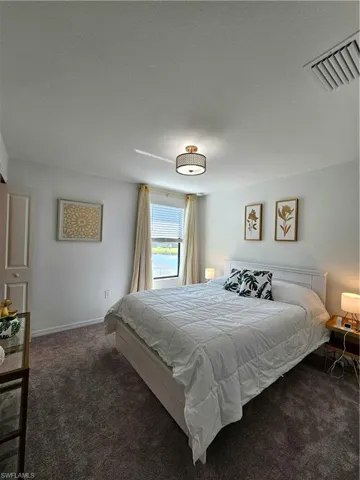 Bedroom featuring dark carpet and a textured ceiling