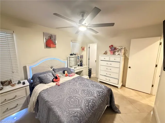 Bedroom with light tile patterned flooring and ceiling fan