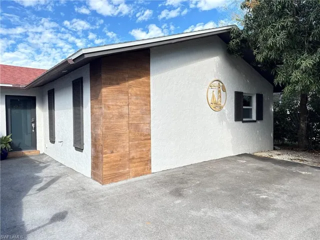 View of property exterior with stucco siding and a patio