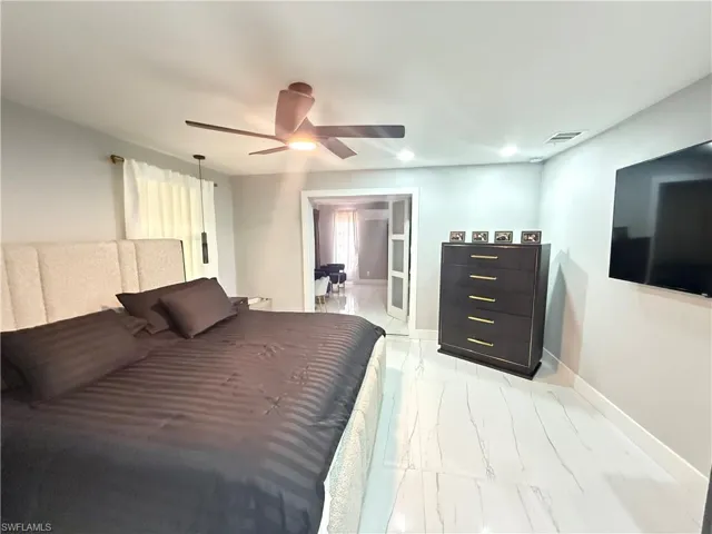 Bedroom with light marble finish flooring and ceiling fan
