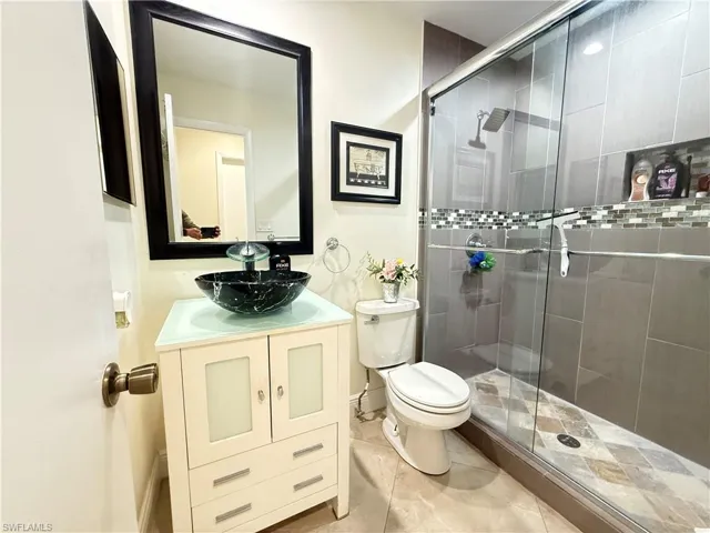 Bathroom with vanity, a shower stall, and light tile patterned flooring