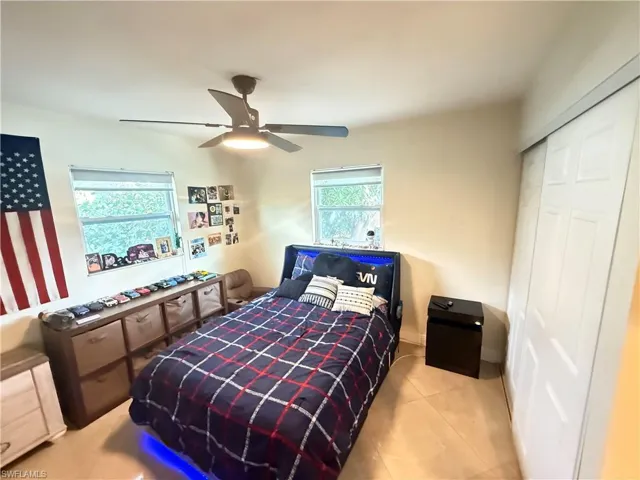 Bedroom featuring a ceiling fan, a closet, and tile patterned floors