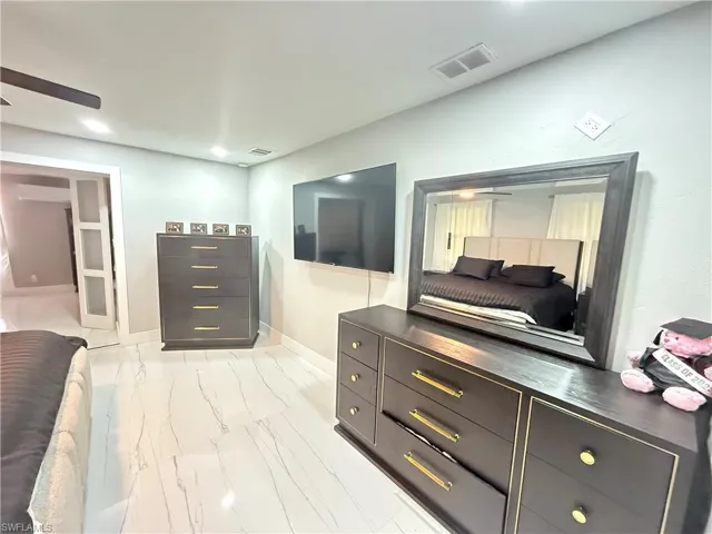 Bedroom featuring light marble finish floors and recessed lighting