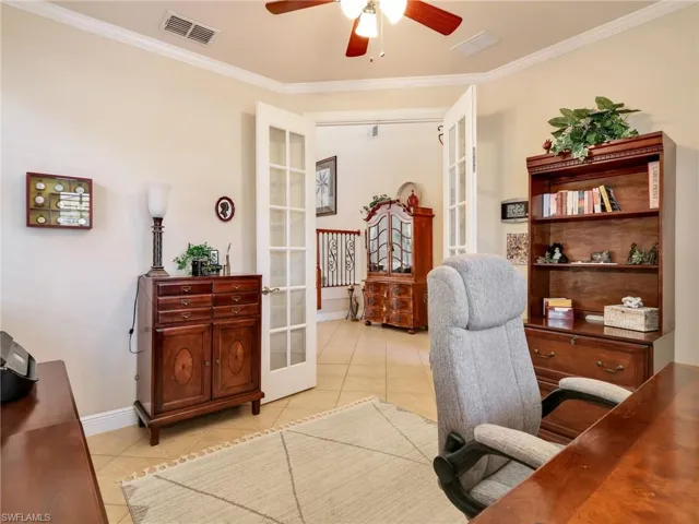 Office with french doors, crown molding, light tile patterned flooring, and ceiling fan