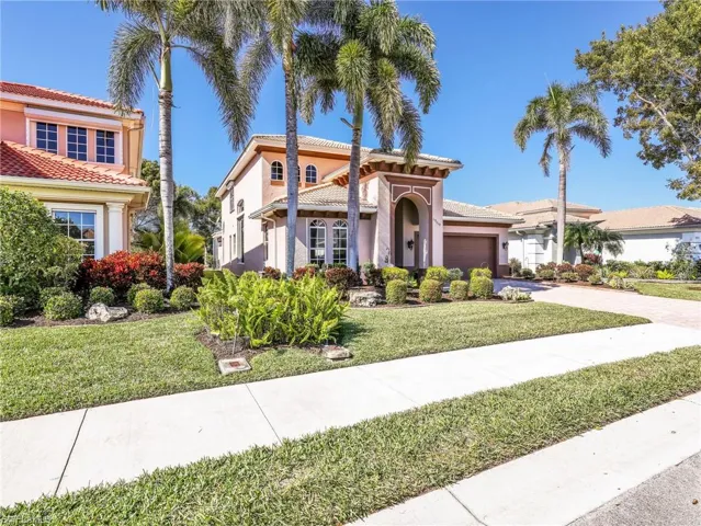 Mediterranean / spanish house featuring driveway, stucco siding, a front lawn, and an attached garage