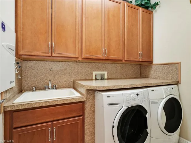 Laundry room with separate washer and dryer and cabinet space