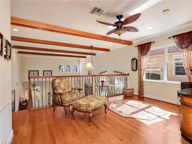 Sitting room featuring wood finished floors, recessed lighting, a ceiling fan, beamed ceiling, and crown molding