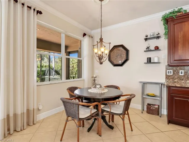 Dining room featuring ornamental molding, a chandelier, and light tile patterned flooring