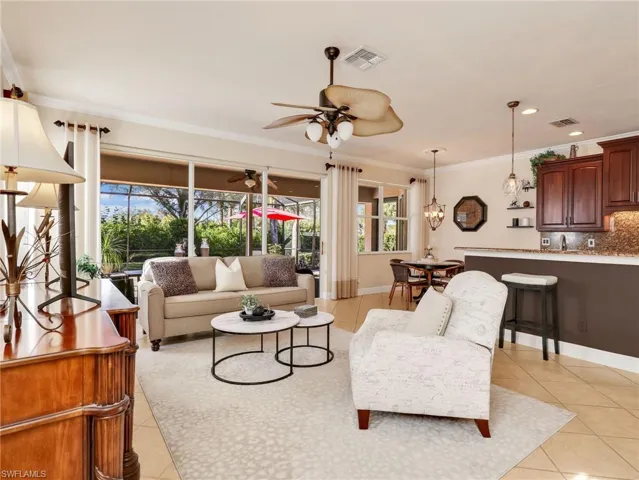 Living room with light tile patterned floors, crown molding, recessed lighting, and ceiling fan
