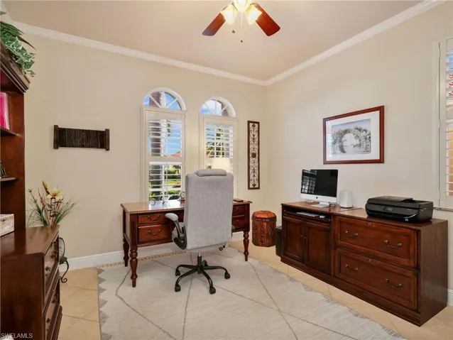 Office space featuring a ceiling fan, crown molding, and light tile patterned floors