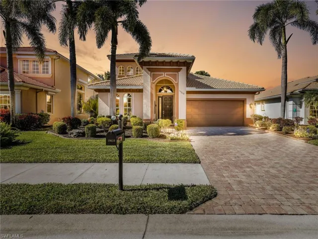 Mediterranean / spanish home with stucco siding, decorative driveway, an attached garage, and a front lawn