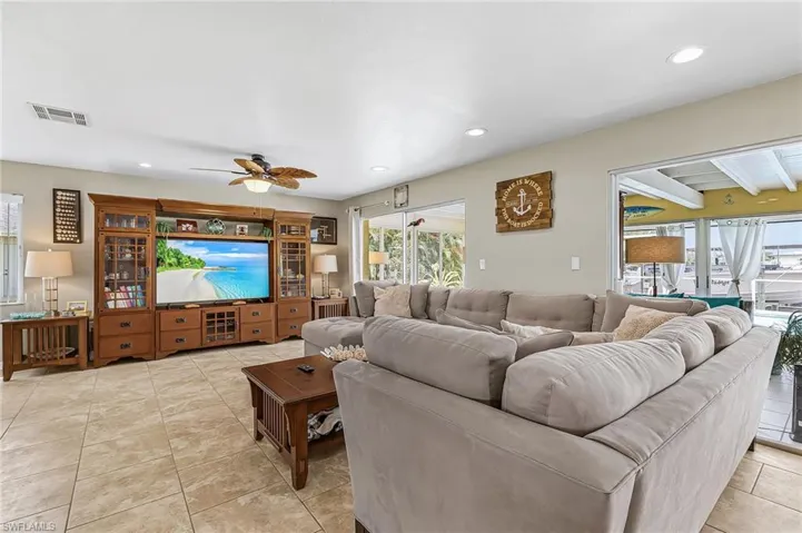 Living area featuring a ceiling fan, recessed lighting, and light tile patterned flooring
