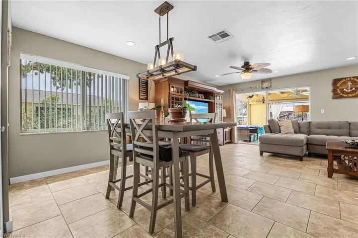 Dining space with a ceiling fan, light tile patterned floors, and recessed lighting