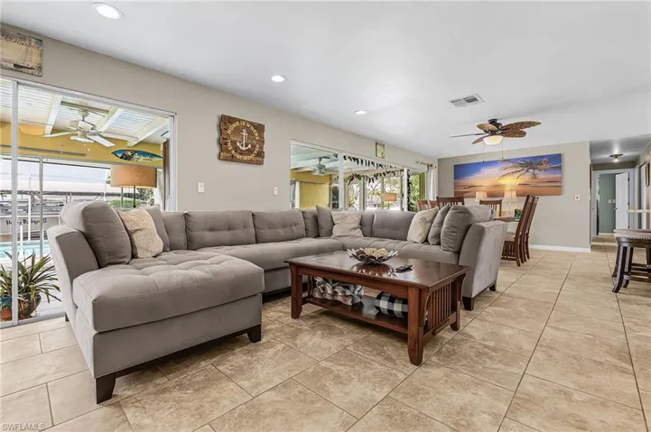 Living area with a ceiling fan, recessed lighting, and light tile patterned floors