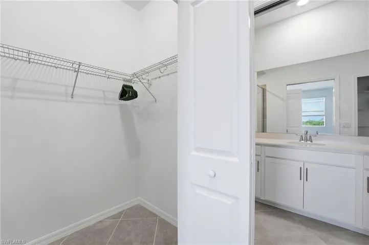 Spacious closet with light tile patterned floors and a sink