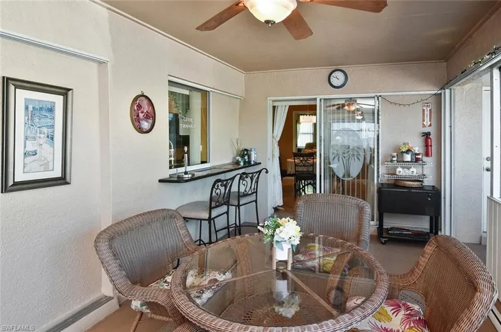 Stepping out onto the lanai, note the pass-through kitchen window and the entertainment bar.
