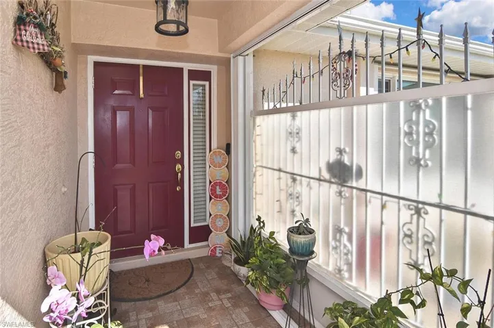 Screened and 'gated' front alcove leads to an elegant front door with shuttered sidelight.