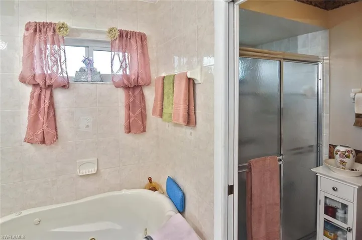 Another view of the owners' bath featuring a walk-in shower in addition to the jetted tub.
