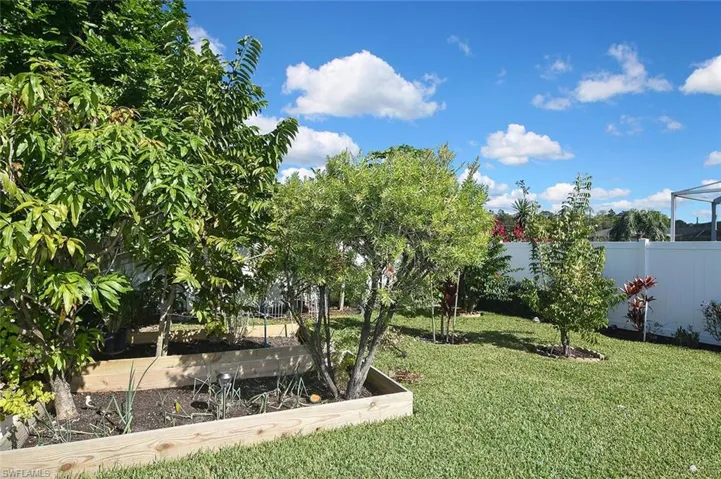 Fenced backyard featuring raised-bed gardens