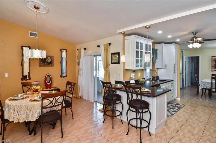 Pendant lighting adorns the breakfast bar space adjacent to the casual dining area.