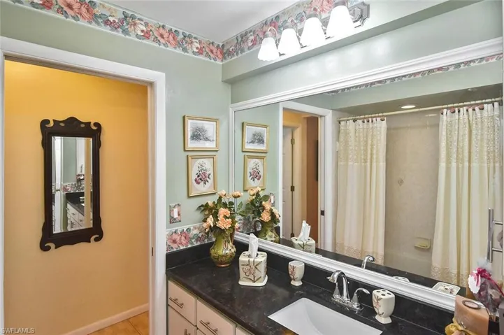 Guest bathroom featuring black granite vanity, tub/shower combo....