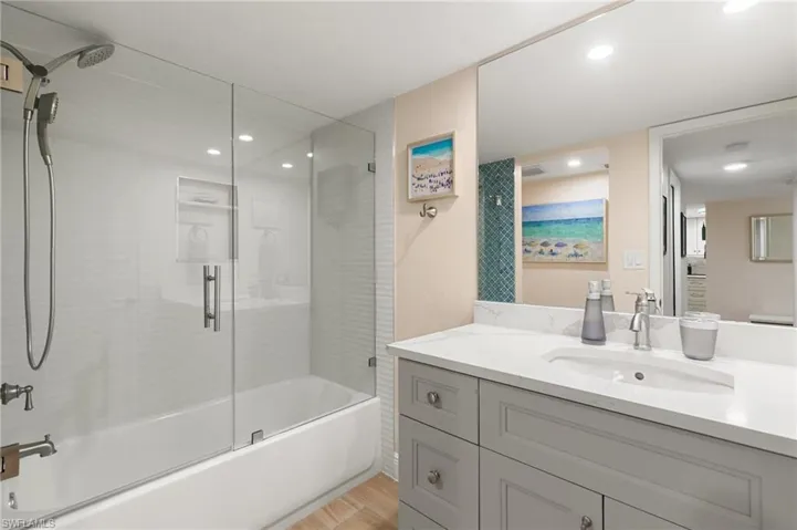 Walk in shower, you can see the back wall of the shower reflected in the mirror, pretty decocrative tile