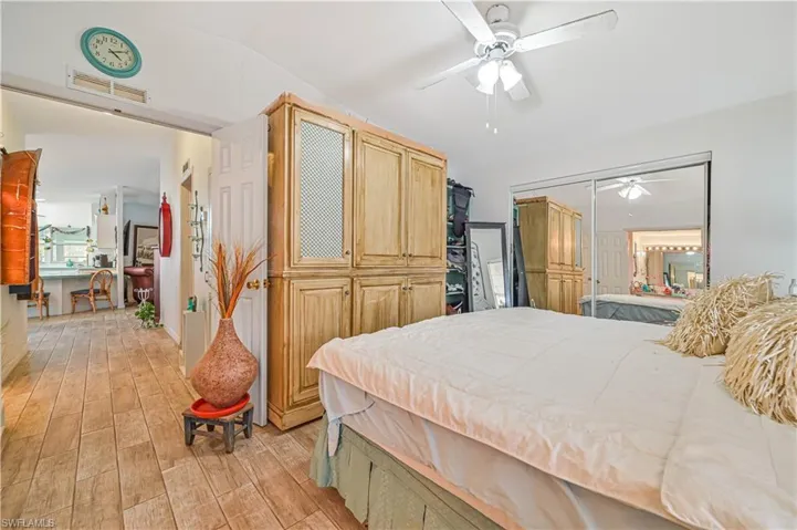Bedroom featuring visible vents, a ceiling fan, light wood-style flooring, and vaulted ceiling