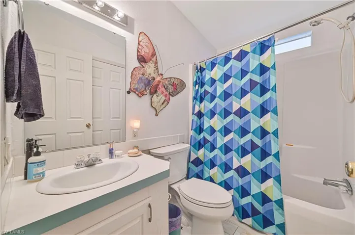 Full bath with toilet, vanity, and shower / bath combo
