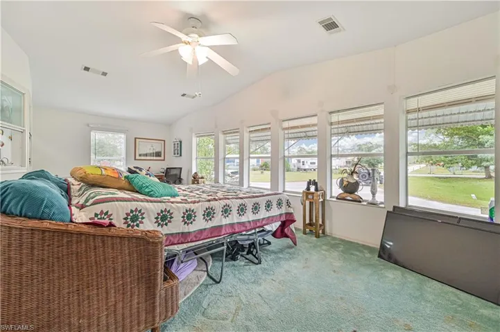 Bedroom featuring carpet flooring, lofted ceiling, ceiling fan, and visible vents(Carpet has been removed)